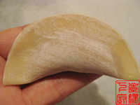 饺子皮对折，一端用水润湿